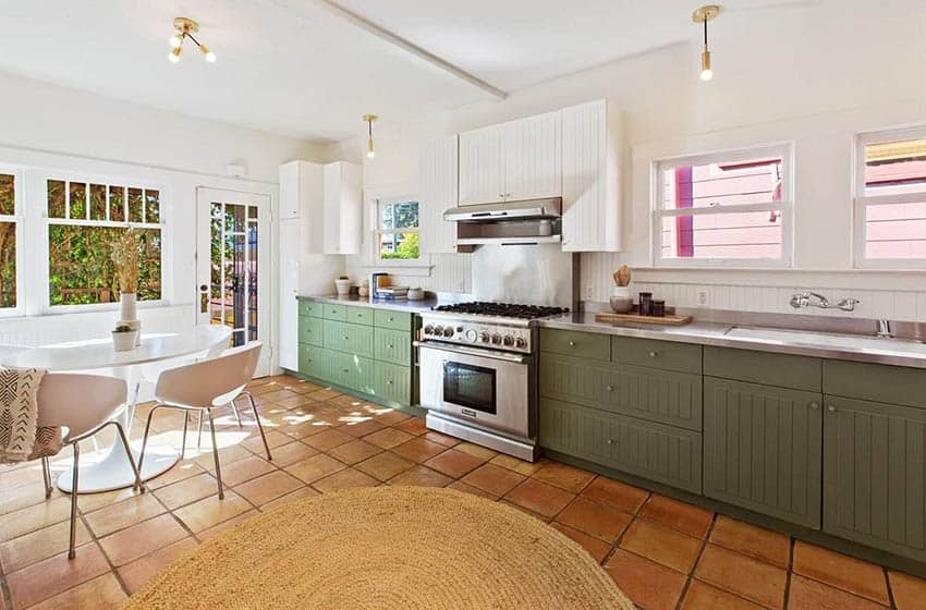 Kitchen with terracotta tile and white and green beadboard cabinets