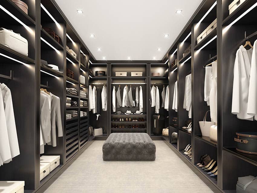 Modern black walk in closet with tufted ottoman
