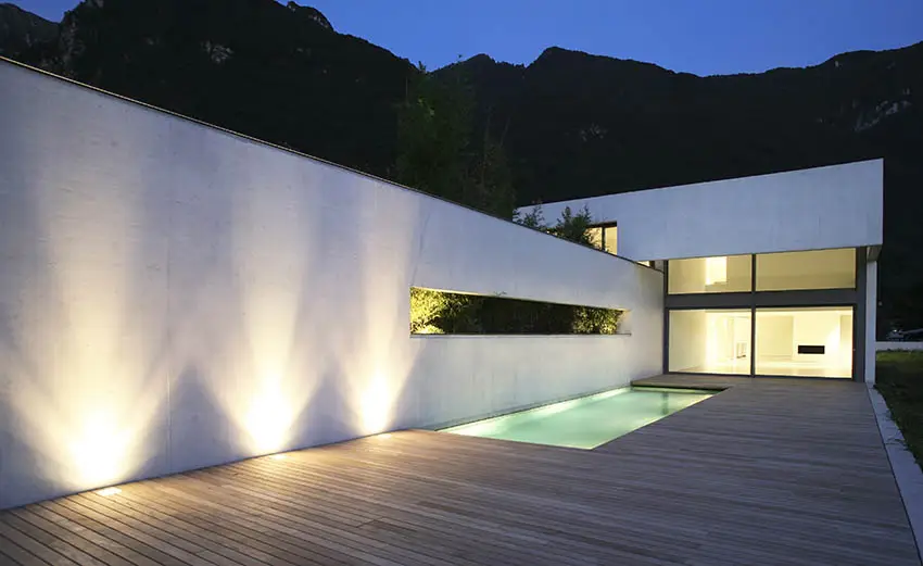 Modern home with plaster walls by swimming pool