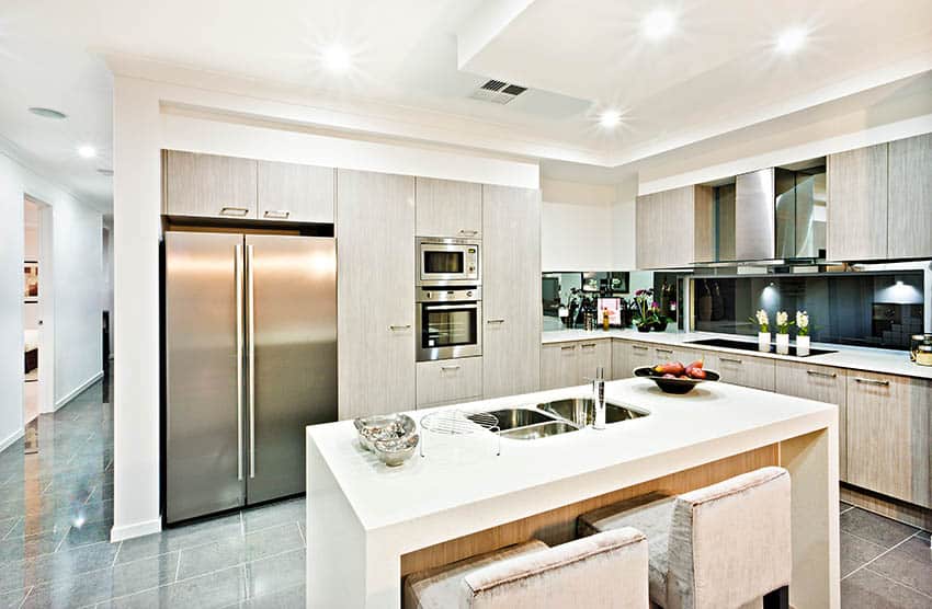 Modern kitchen with concrete tiles, cream color cabinets and white corian waterfall island