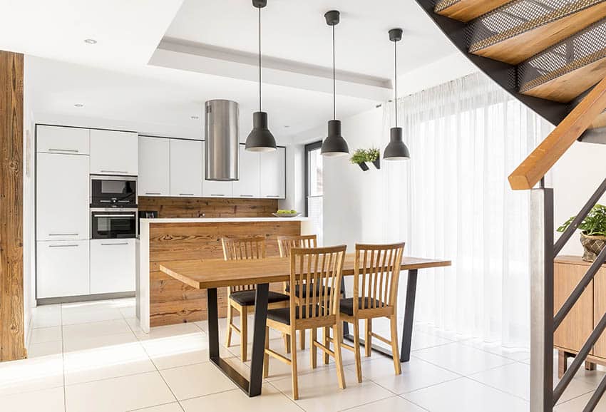 Modern kitchen with tile floors, white cabinets with wood island