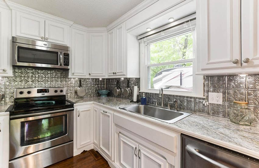 White raised panel kitchen with tin piece wall cladding