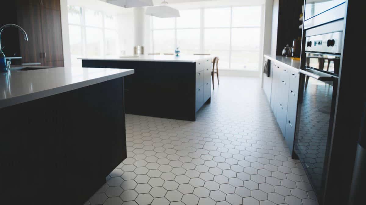 White hexagon floor tiles contrasting with sleek black kitchen cabinetry