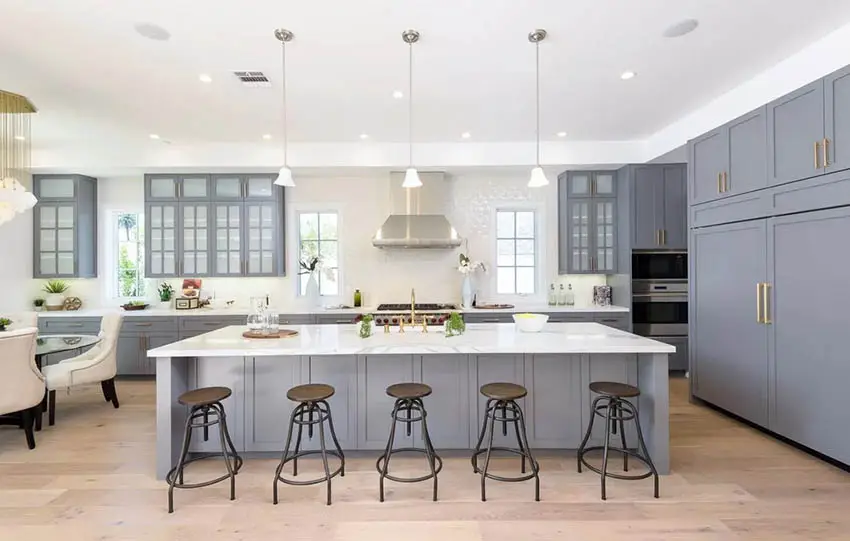 Kitchen with gray cabinets, calacatta quartz countertops and light wood flooring