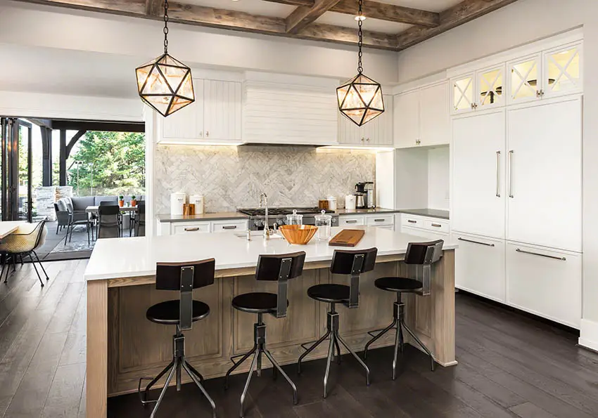 Kitchen with marble backsplash and countertops wood beams