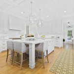 Kitchen with timeless white cabinets, marble countertops and wood flooring