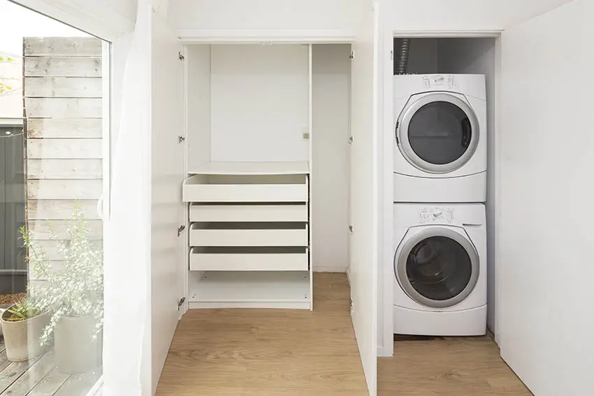 Linen closet in laundry room with chest of drawers