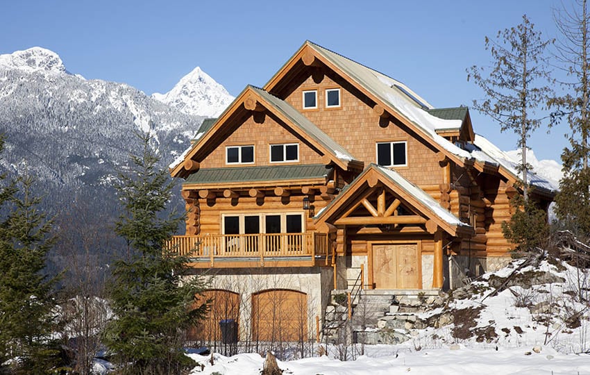 Log home with balcony and view of snow-capped mountains