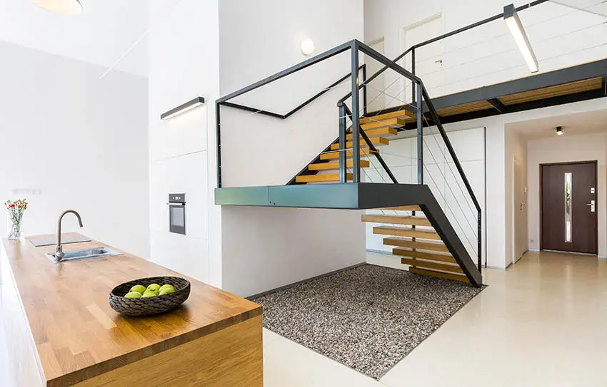 Staircase with wooden frames and metal column supports and island bar 