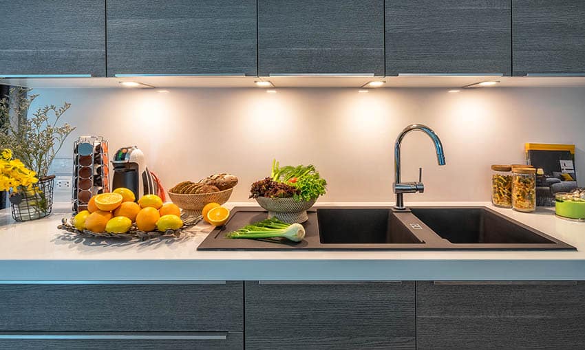 Modern kitchen with double sink, white quartz counters and dark wood veneer cabinets