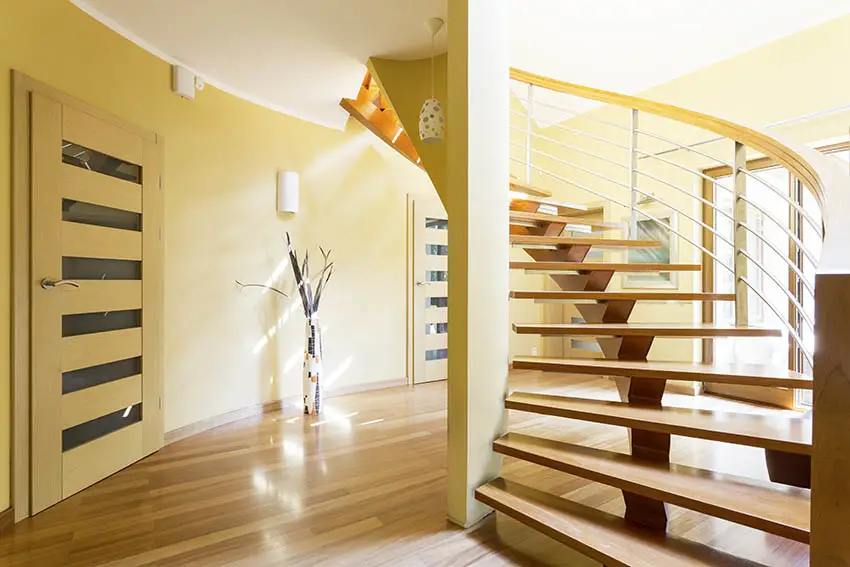 U-shaped stairs, yellow walls, door and floor vase
