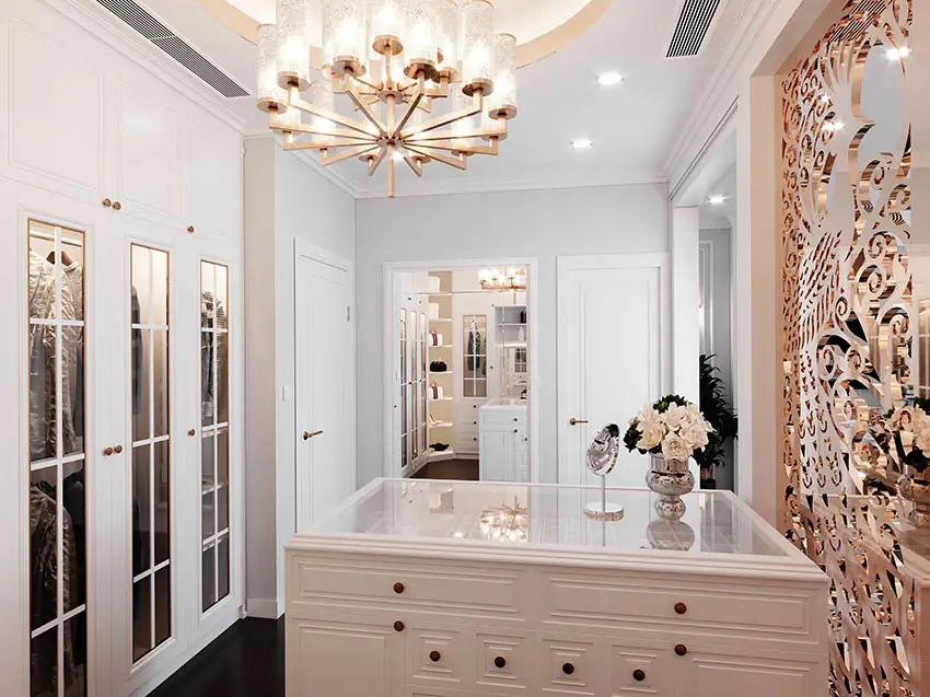 Walk in closet with glass countertop island, decorative accent wall and glass door cabinets