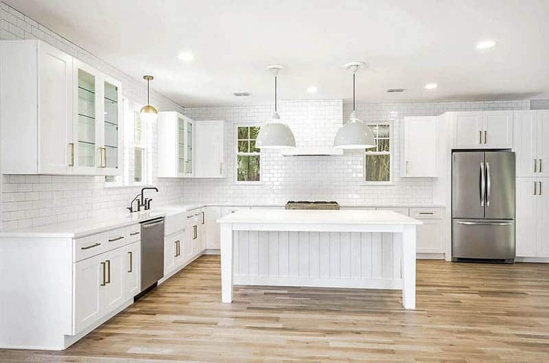 All white kitchen with vertical shiplap island white cabinets subway tile quartz countertops
