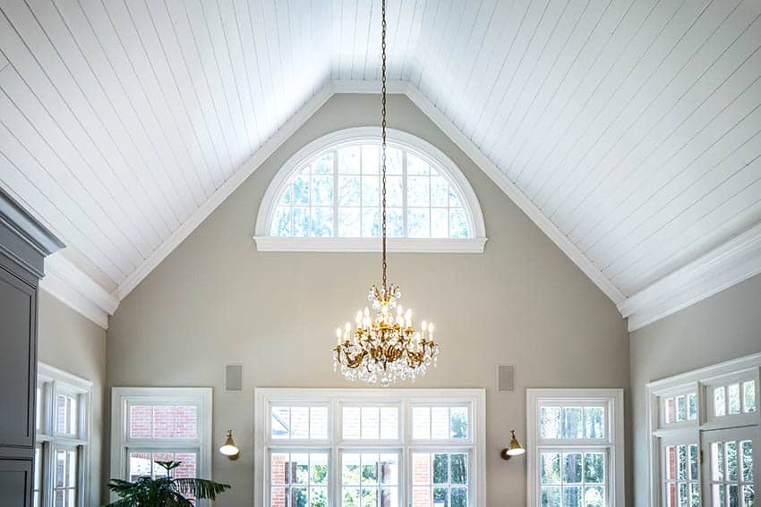 Arched custom window in high ceiling living room with chandelier