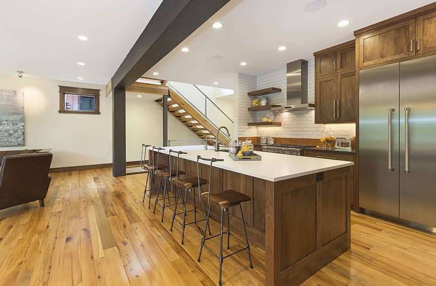 Basement kitchen with large island quartz countertop and wood cabinets