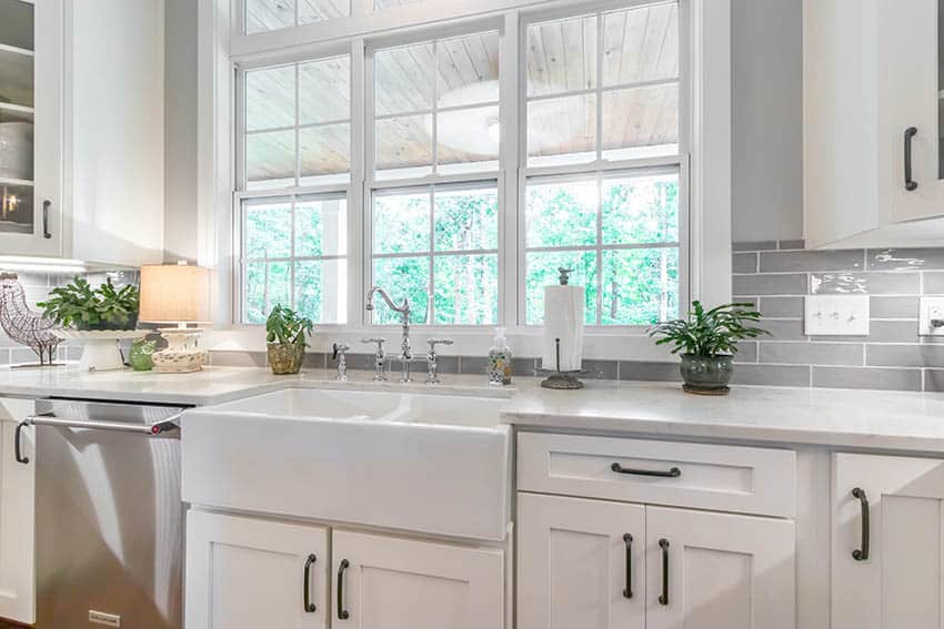 Beautiful kitchen window above farmhouse sink with shaker cabinets gray subway tile