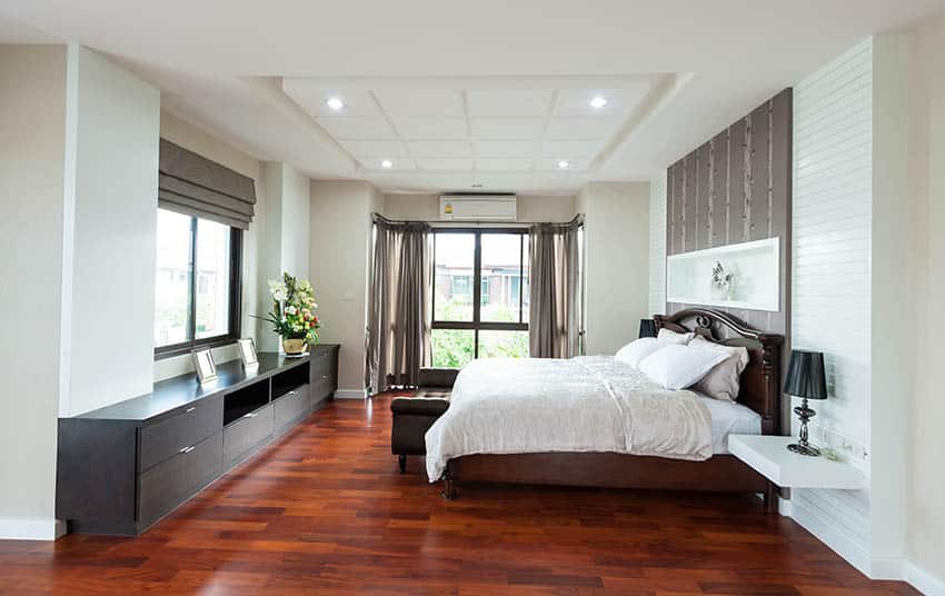 Bedroom with cherry wood floors, beige and white paint