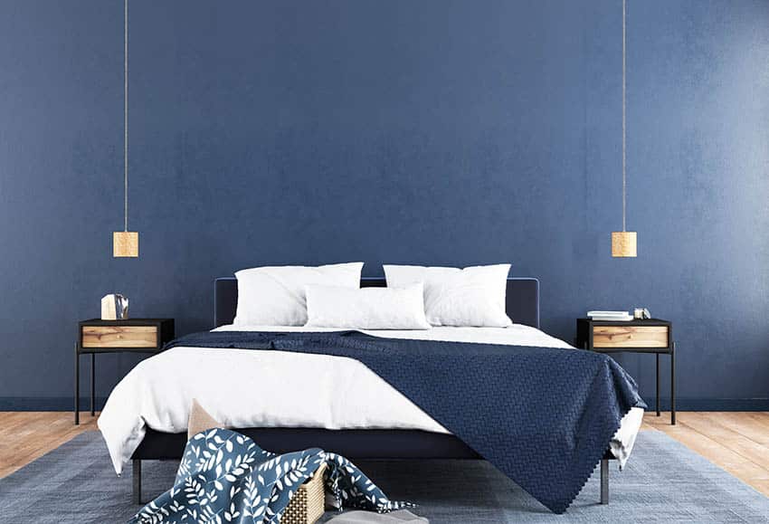 Bedroom with blue walls, white pillows and blue gray carpet