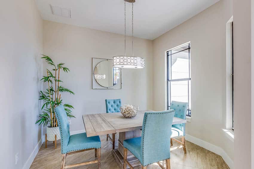 Dining room with light wood floors and taupe wall paint blue chairs wood table