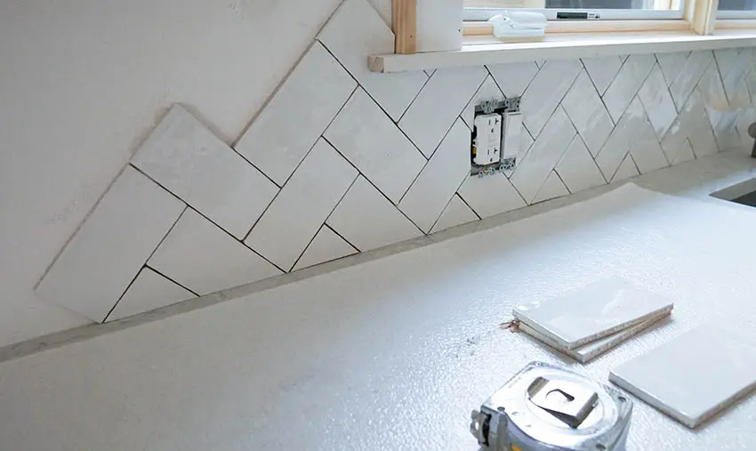 Installing herringbone tile backsplash in kitchen
