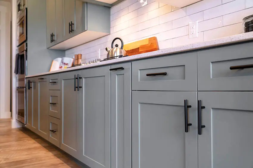 Kitchen with grey shaker cabinets black pulls white subway tile