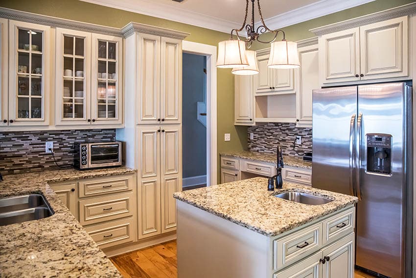 Kitchen with raised panel cabinets with cream chalk paint and island