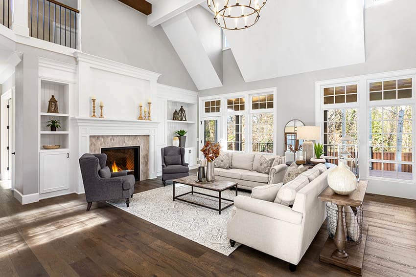 Room with white couch, gray accent chairs, panel windows and wooden console table