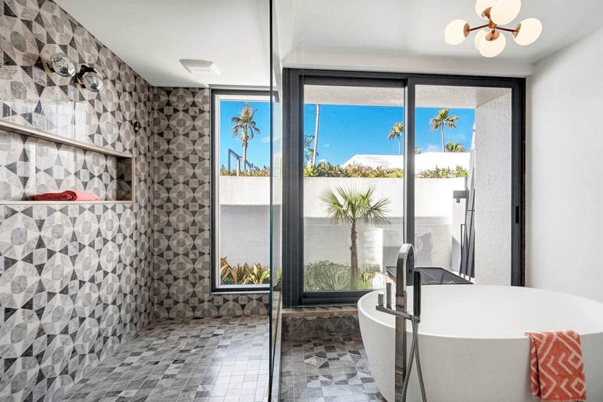 Shower with framed partitions made of glass and geometric tiles on walls
