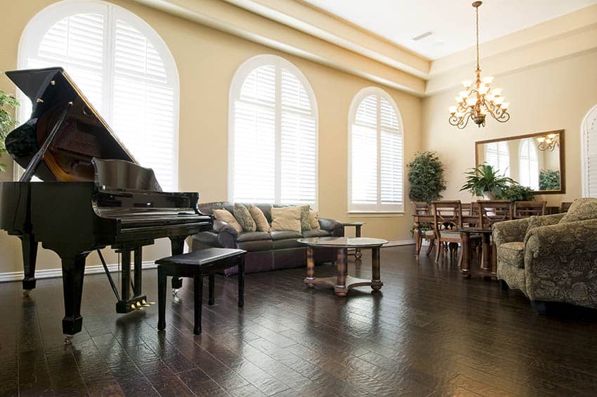 Living room with dark wood floors and pastel yellow paint grand piano