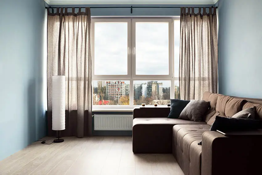 Living room with light blue paint color brown sofa and brown curtains