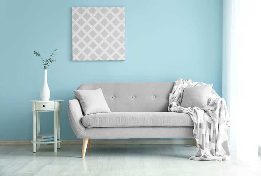 Living room with light blue paint walls and light grey sofa and flooring