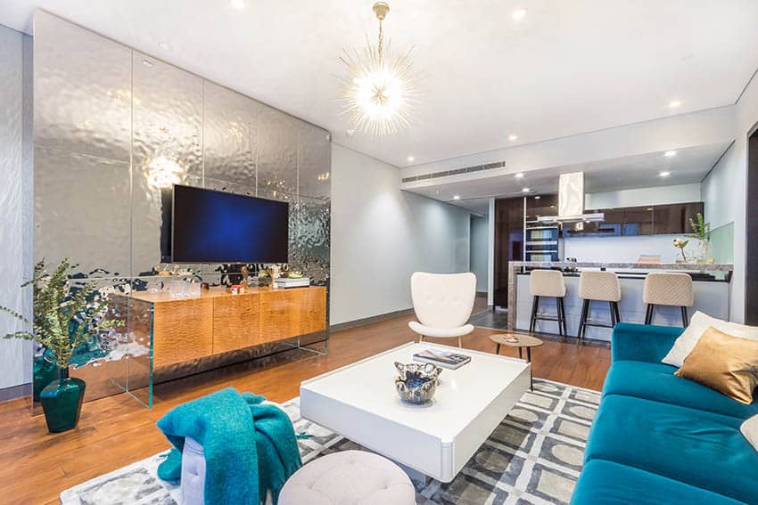 Modern living space with mirror accent wall and stained wood flooring