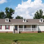 Ranch style modular home with gables fenced front porch