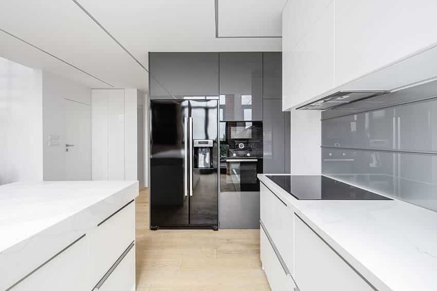 Galley kitchen combined with white cabinets and a cooktop