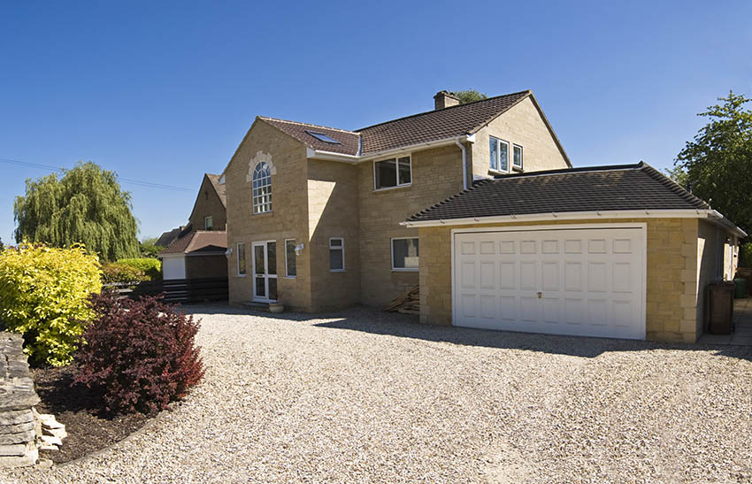 White garage door with gravel pathway