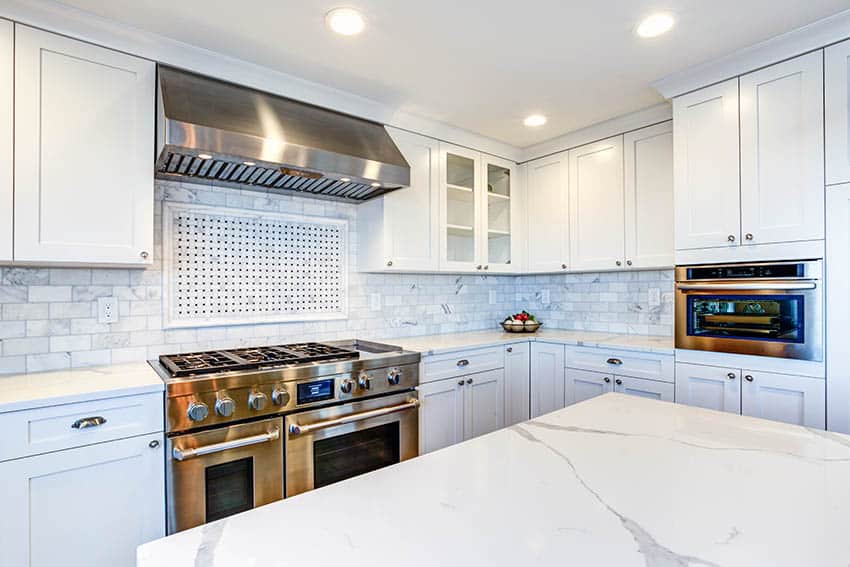 Kitchen with white painted shaker cabinets calacatta quartz countertops