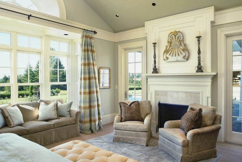 Living room with french windows large fireplace with armchairs