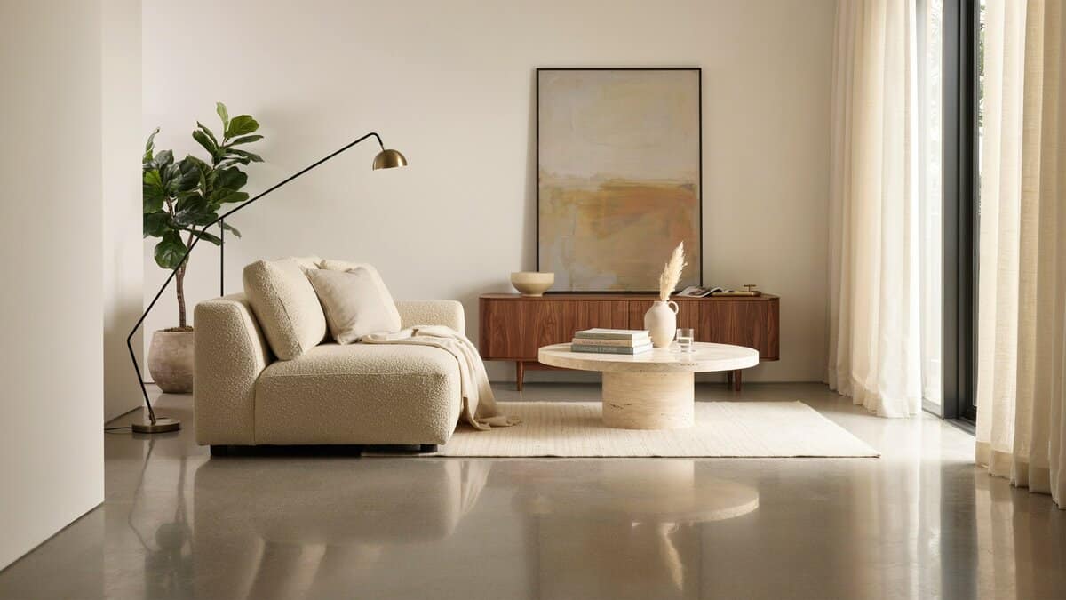 Minimal living room with a polished gray epoxy floor reflecting sheer curtains and daylight