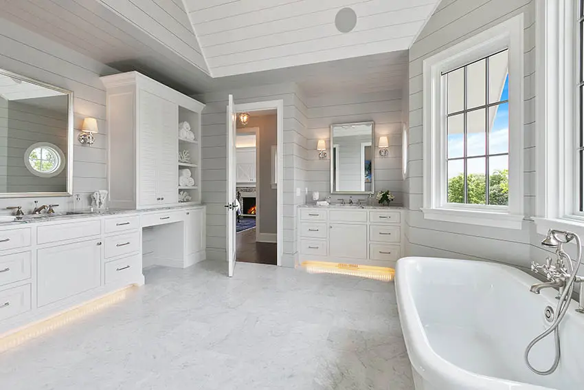 Master bathroom with picture window above tub shiplap walls white vanities