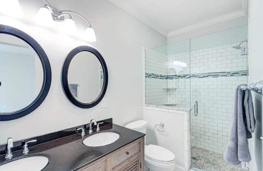 Master bathroom with subway tile shower dual round mirrors