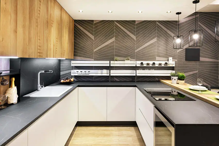 U shaped kitchen with soapstone countertops, geometric wall tile and two color cabinets