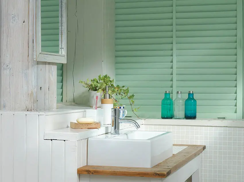 Small bathroom with green plantation shutters