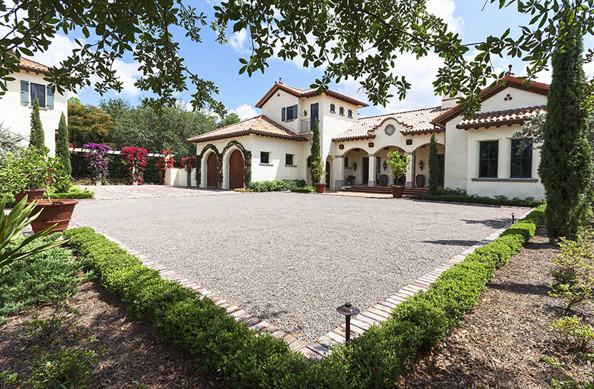 Spanish style home with gravel driveway