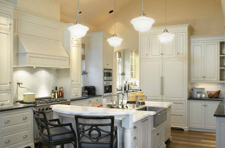 Traditional kitchen with shaker cabinets marble countertops raised breakfast bar wood flooring