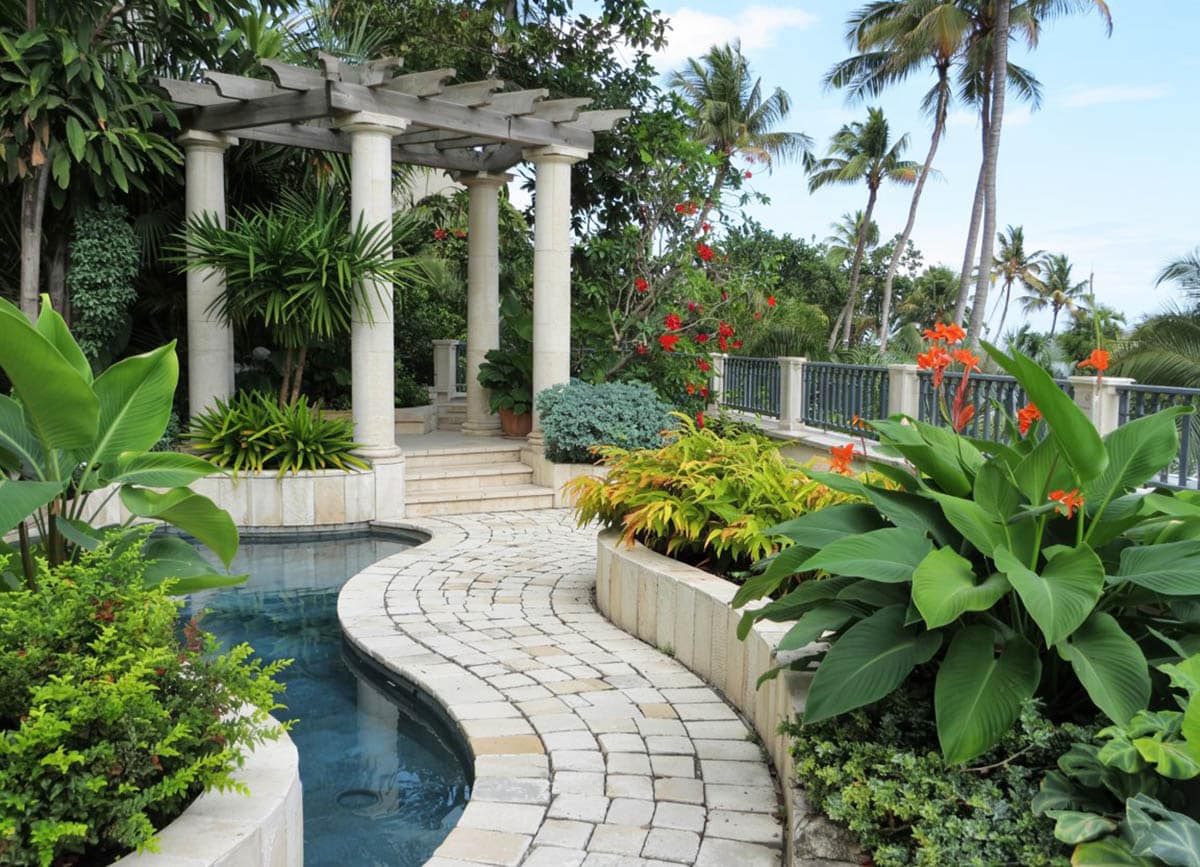 Tropical landscaped garden with path to pillar pergola