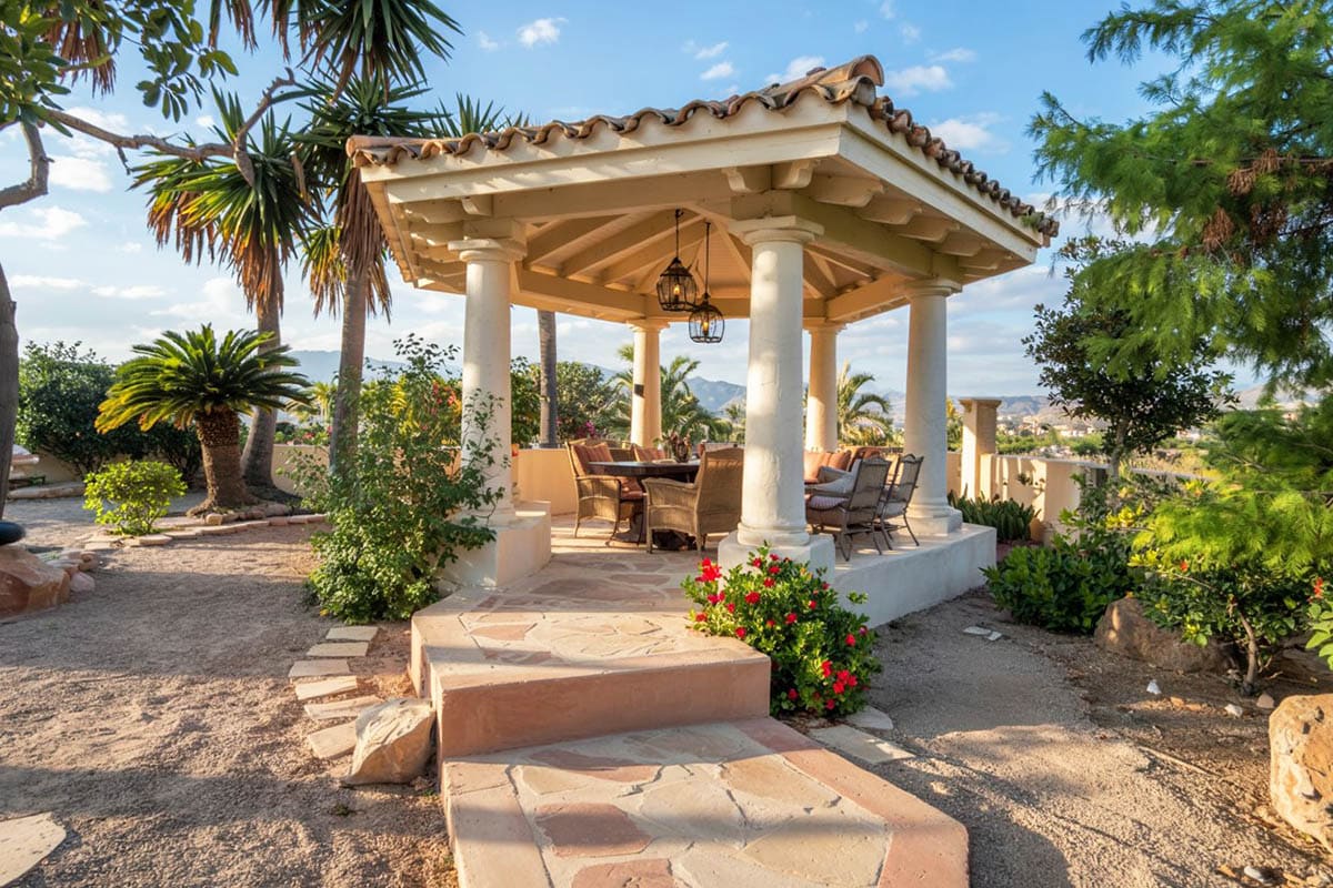 Tuscan style gazebo in landscaped backyard
