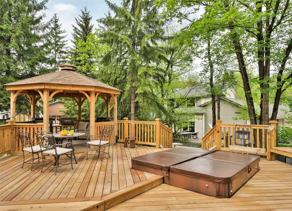 Deck with gazebo and spa in backyard of home