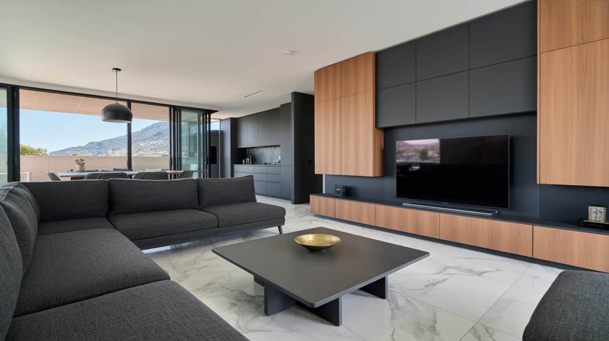 Modern minimalist masculine living room with dark gray sectional sofa, wood panel TV wall, and polished marble floor