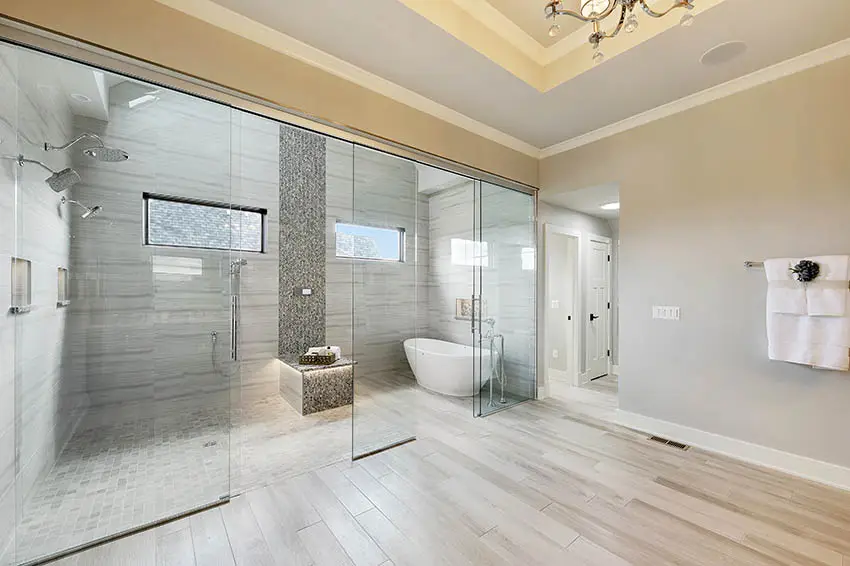 Bathroom with zero entry shower with lighted bench freestanding tub