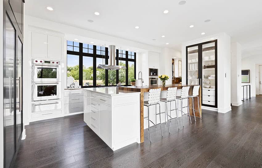 Contemporary kitchen with two tier island with wood breakfast bar quartz countertops white cabinets
